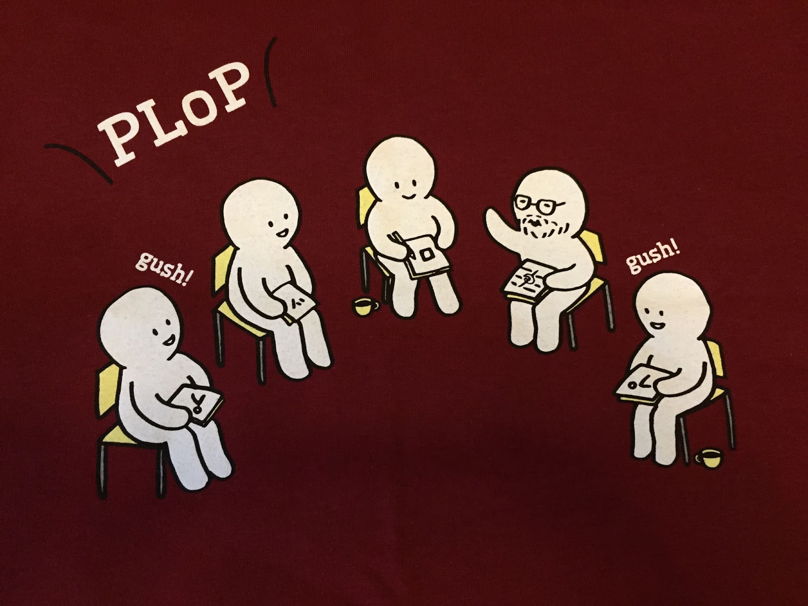 Five small cartoon characters seated in a semi circle. One person who has glasses and a beard is raising his hand and speaking. Two others in the circle are saying gush. (Gush is a code word people at PLoP use to indicate they agree with what was just said.)